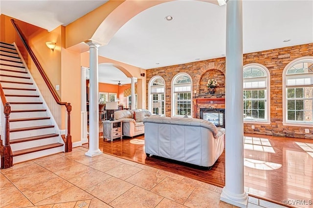 living room with a fireplace, light tile patterned floors, ceiling fan, and a healthy amount of sunlight