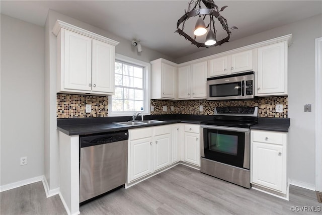 kitchen featuring sink, stainless steel appliances, light hardwood / wood-style flooring, backsplash, and white cabinets