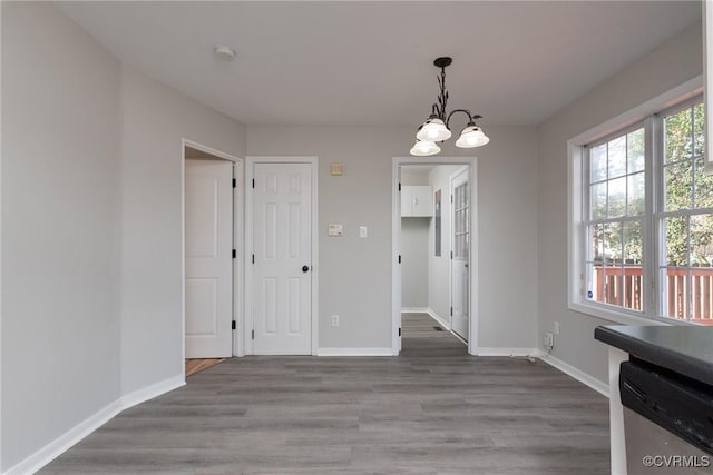 unfurnished dining area with hardwood / wood-style flooring and an inviting chandelier