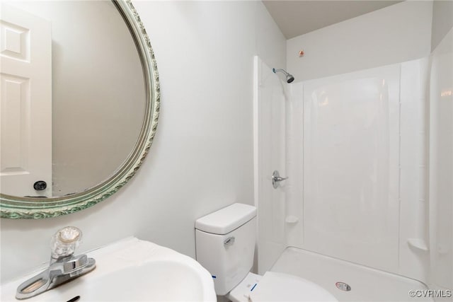 bathroom featuring a shower, sink, and toilet