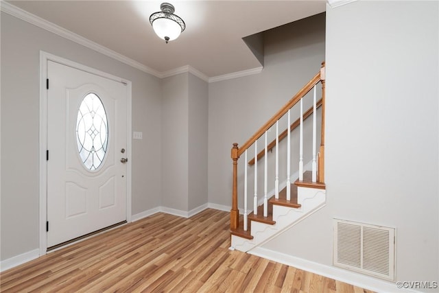 foyer featuring crown molding and light hardwood / wood-style flooring