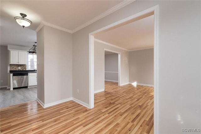 empty room featuring ornamental molding and light hardwood / wood-style flooring