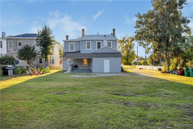 rear view of property featuring a yard