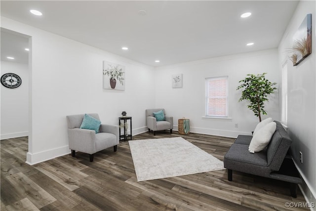 sitting room with crown molding and dark wood-type flooring