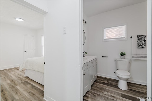 bathroom featuring wood-type flooring, vanity, and toilet