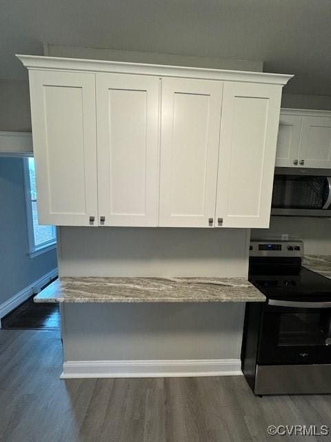 kitchen with dark hardwood / wood-style flooring, white cabinetry, and appliances with stainless steel finishes