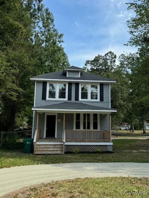 view of front of property with covered porch and a front lawn