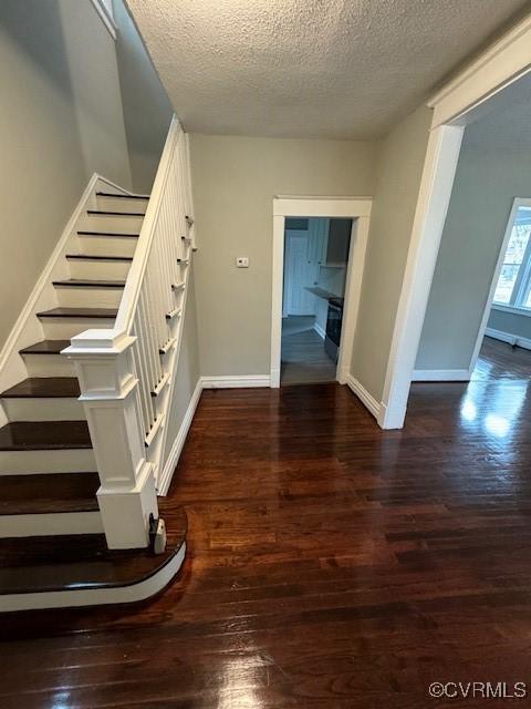 stairway featuring wood-type flooring and a textured ceiling