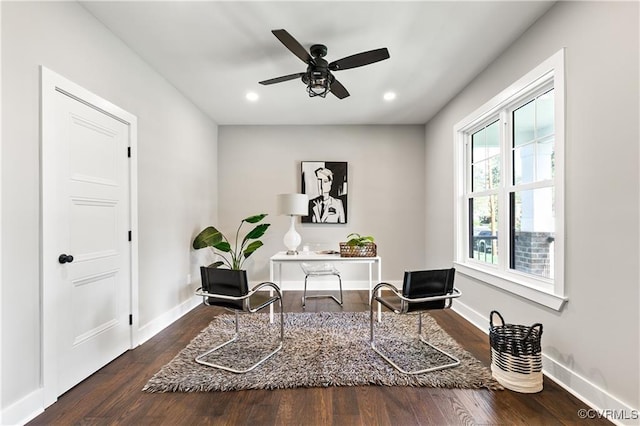 sitting room with ceiling fan and dark wood-type flooring