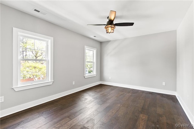 empty room with ceiling fan, dark hardwood / wood-style flooring, and a wealth of natural light