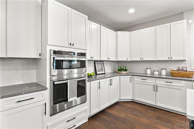 kitchen with dark hardwood / wood-style floors, decorative backsplash, white cabinetry, and double oven