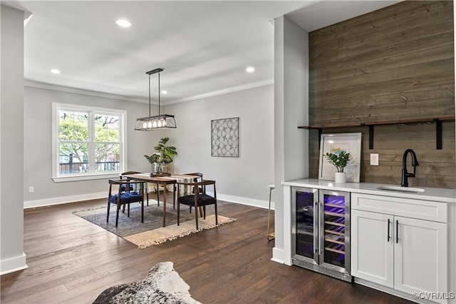 interior space featuring crown molding, sink, decorative light fixtures, white cabinets, and wine cooler