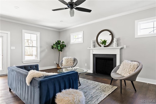 living room featuring ornamental molding, a wealth of natural light, dark wood-type flooring, and ceiling fan