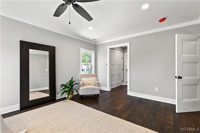 living area with ceiling fan, dark hardwood / wood-style flooring, and ornamental molding