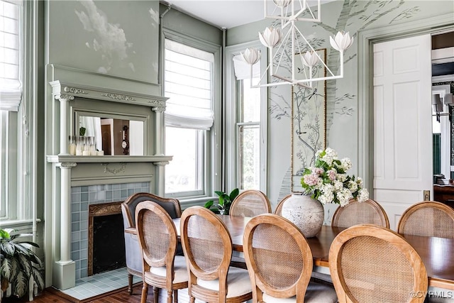 dining area with hardwood / wood-style floors, a fireplace, and a chandelier