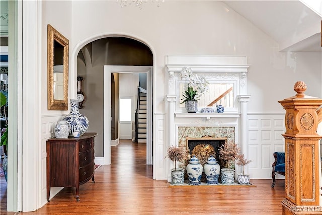 living room featuring hardwood / wood-style flooring, lofted ceiling, and a high end fireplace