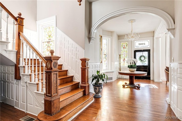 entrance foyer with wood-type flooring and a notable chandelier