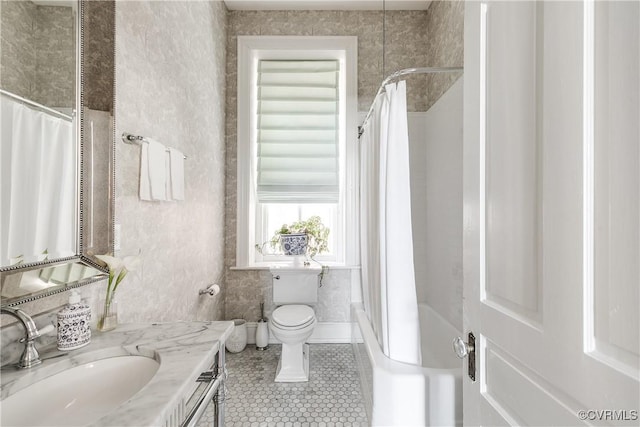 full bathroom featuring tile patterned flooring, vanity, toilet, and shower / bath combo with shower curtain