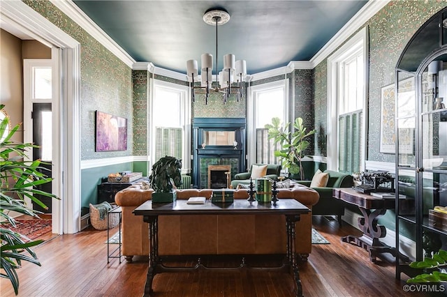 home office with a notable chandelier, crown molding, a tile fireplace, and hardwood / wood-style flooring