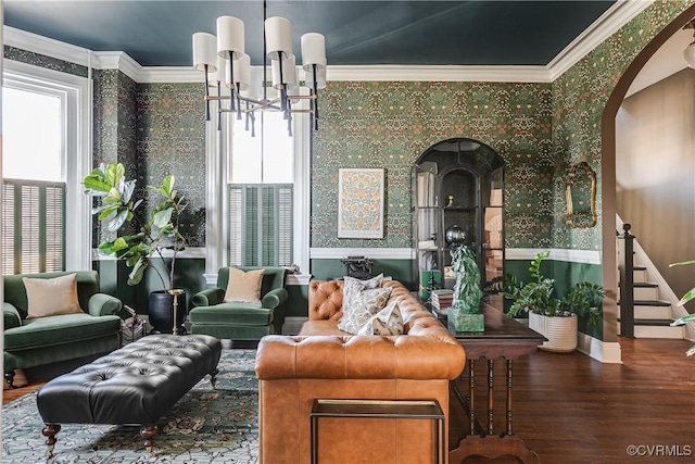 living room with crown molding, wood-type flooring, and a notable chandelier