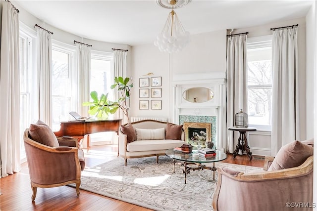 living area featuring hardwood / wood-style floors, a notable chandelier, and a premium fireplace