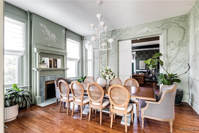 dining area with hardwood / wood-style floors, a wealth of natural light, and a notable chandelier