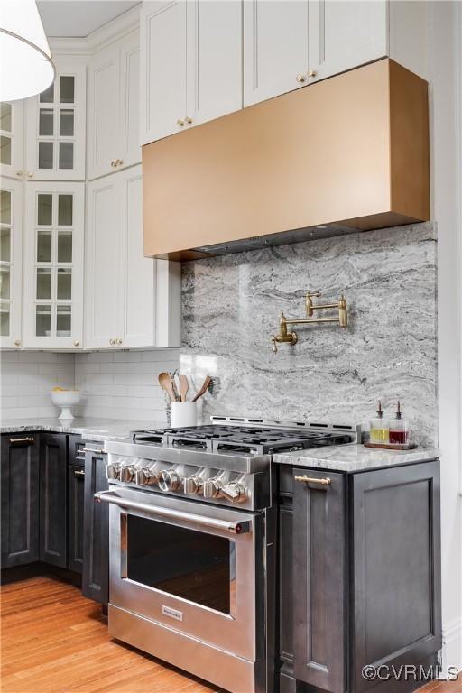 2002 Princess Anne Ave, Richmond, VA 23223 - kitchen with high end stainless steel range oven, white cabinetry, and decorative backsplash