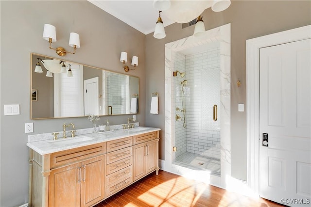 bathroom with hardwood / wood-style flooring, vanity, and an enclosed shower