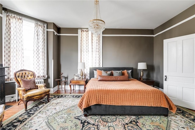 bedroom featuring multiple windows, hardwood / wood-style floors, and a chandelier