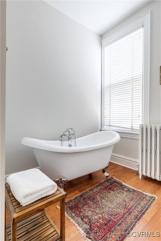 2002 Princess Anne Ave, Richmond, VA 23223 - full bath featuring radiator, a soaking tub, and wood finished floors