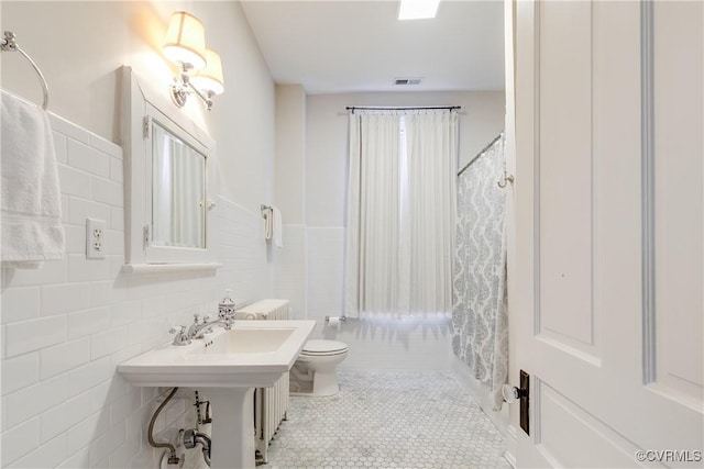 bathroom with tile walls, a shower with curtain, tile patterned floors, and toilet