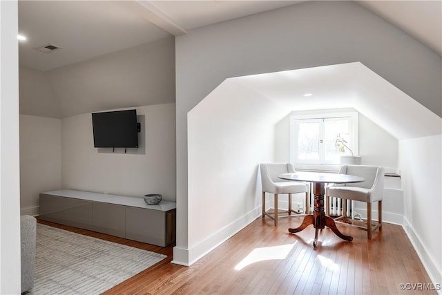 interior space featuring lofted ceiling and light hardwood / wood-style flooring