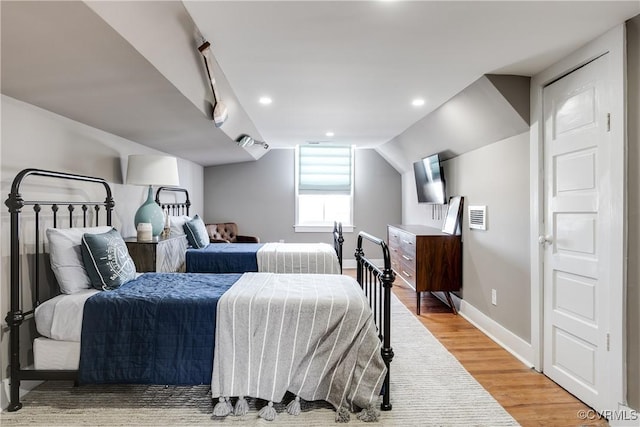 bedroom with wood-type flooring and lofted ceiling