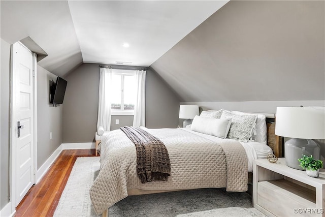 bedroom featuring hardwood / wood-style flooring and vaulted ceiling