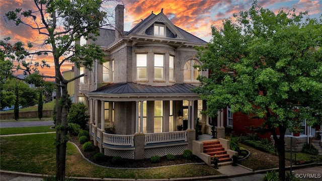 2002 Princess Anne Ave, Richmond, VA 23223 - victorian house featuring covered porch, brick siding, a chimney, and a metal roof
