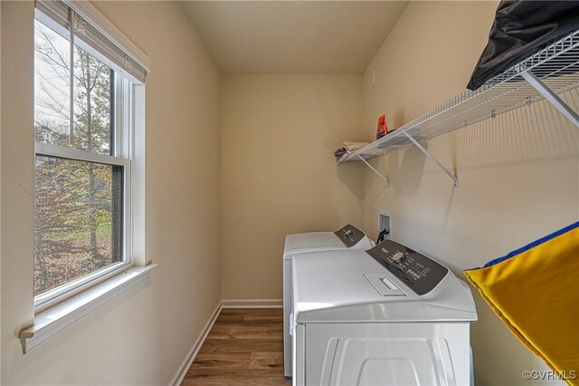 washroom featuring dark hardwood / wood-style flooring, a wealth of natural light, and washing machine and clothes dryer