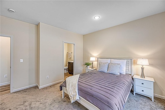 bedroom featuring connected bathroom and carpet floors