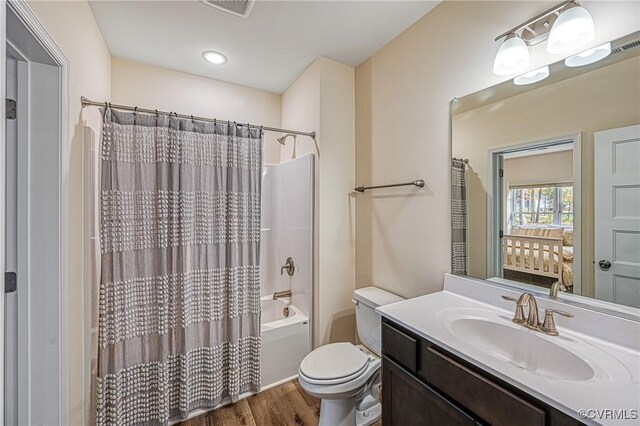 full bathroom featuring vanity, wood-type flooring, shower / bath combo, and toilet