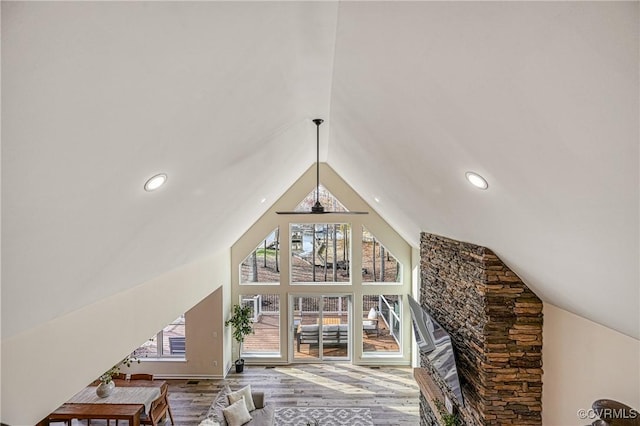 living room with hardwood / wood-style floors, high vaulted ceiling, and ceiling fan