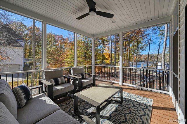 sunroom / solarium featuring a water view and ceiling fan