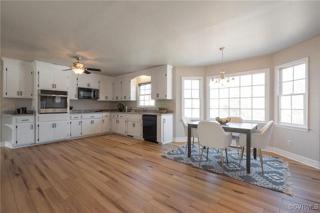 kitchen featuring ceiling fan with notable chandelier, black appliances, light hardwood / wood-style flooring, white cabinetry, and hanging light fixtures