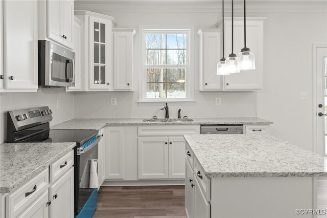 kitchen featuring white cabinets, appliances with stainless steel finishes, decorative light fixtures, and sink