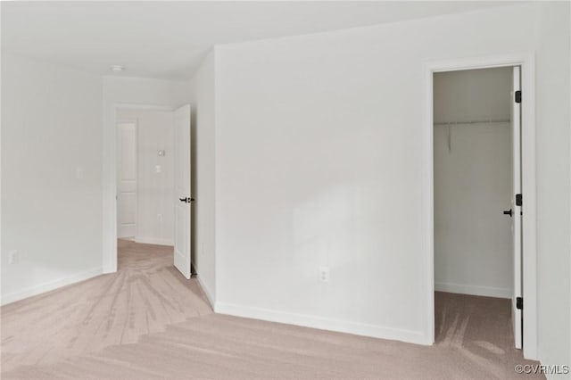 unfurnished bedroom featuring a spacious closet and a closet