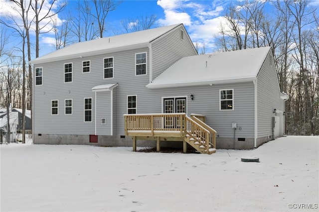 snow covered rear of property with a deck