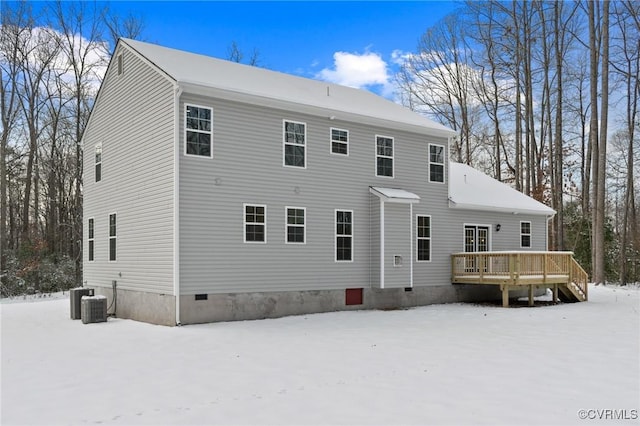 snow covered property with a deck and central AC