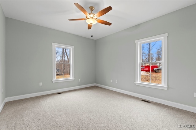 carpeted spare room with ceiling fan