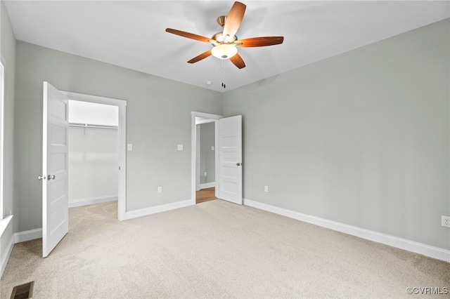 unfurnished bedroom featuring carpet, ceiling fan, a spacious closet, and a closet