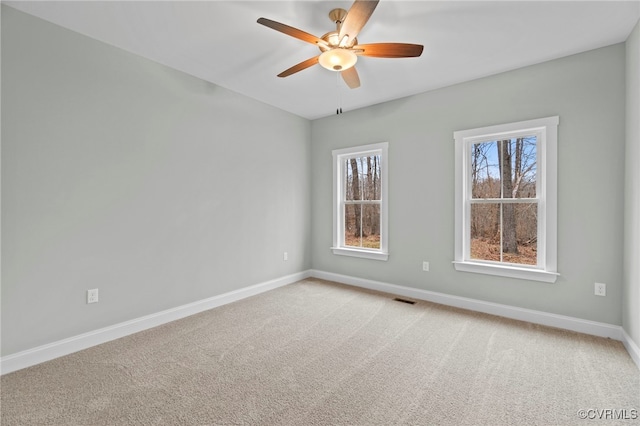 spare room with light colored carpet and ceiling fan