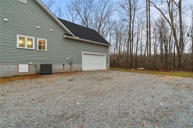 view of property exterior with a garage and central AC