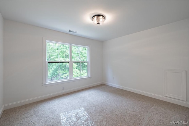 unfurnished room featuring light carpet